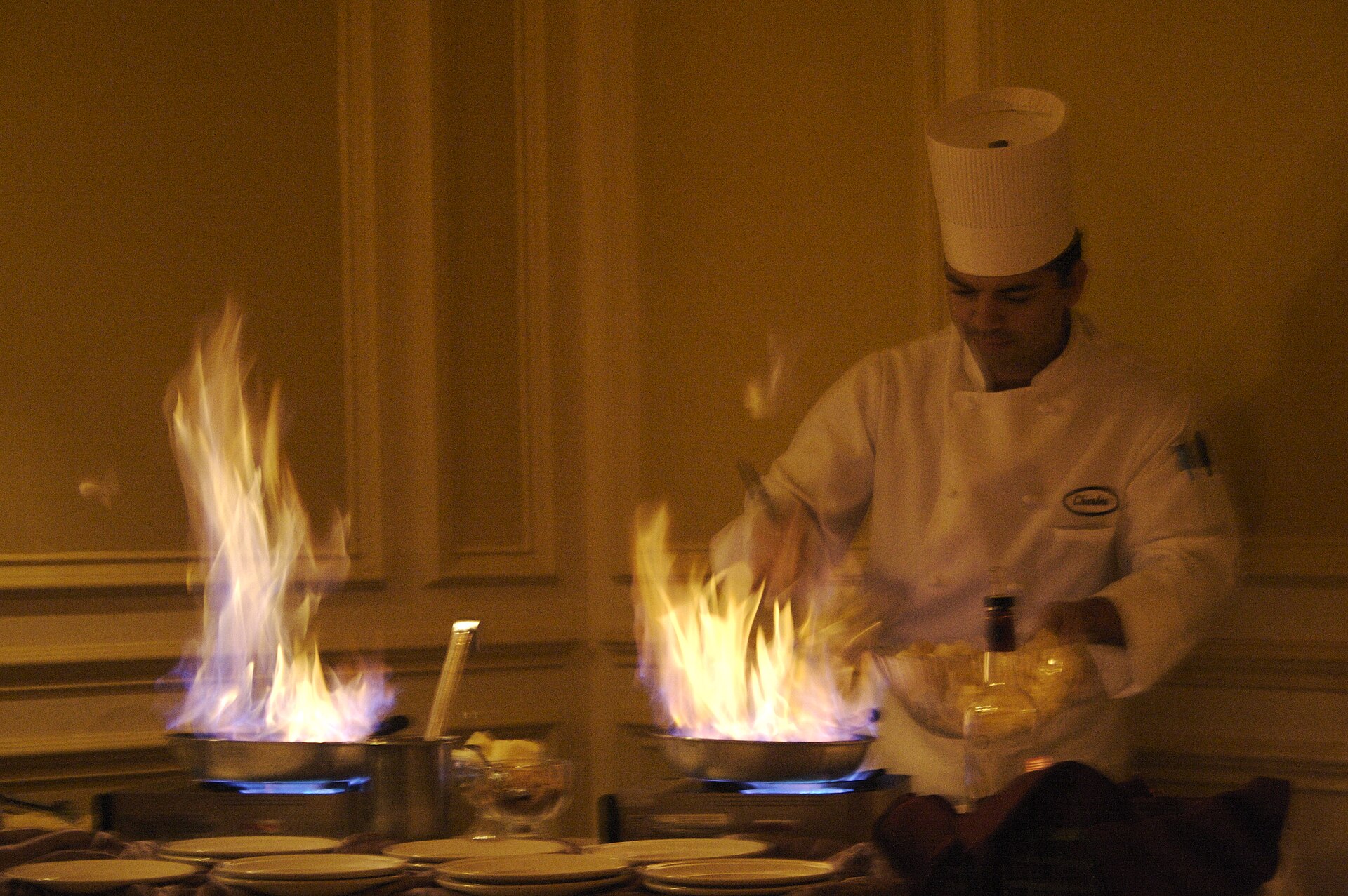 Chef flambéing crêpes in a pan