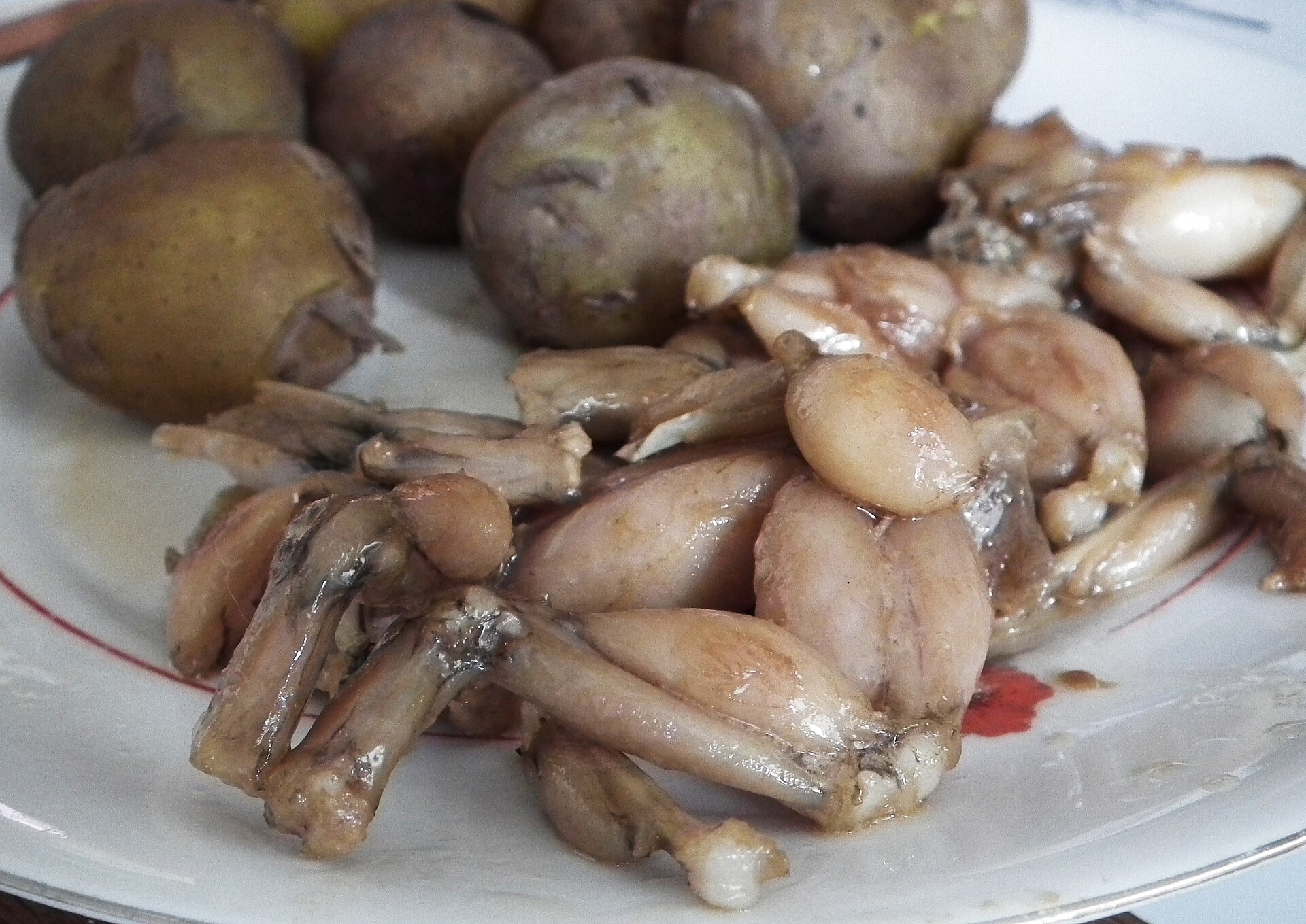 Pan-fried frog legs served with potatoes